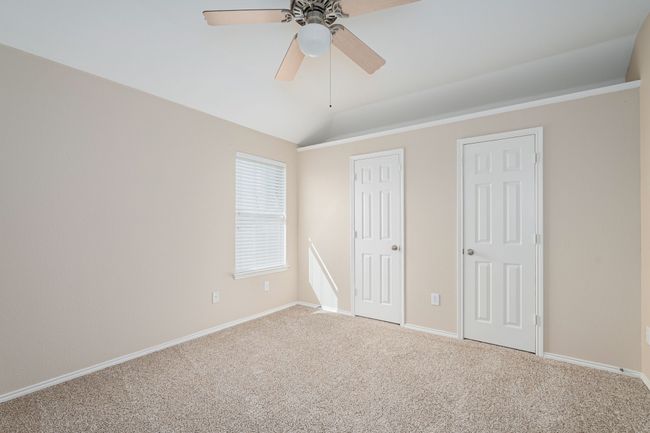 Unfurnished bedroom featuring carpet, vaulted ceiling, and ceiling fan | Image 25