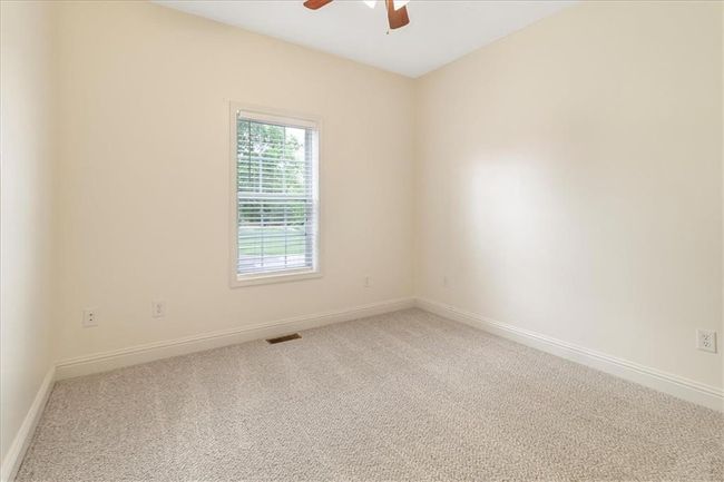 Carpeted spare room featuring a ceiling fan, baseboards, and visible vents | Image 24