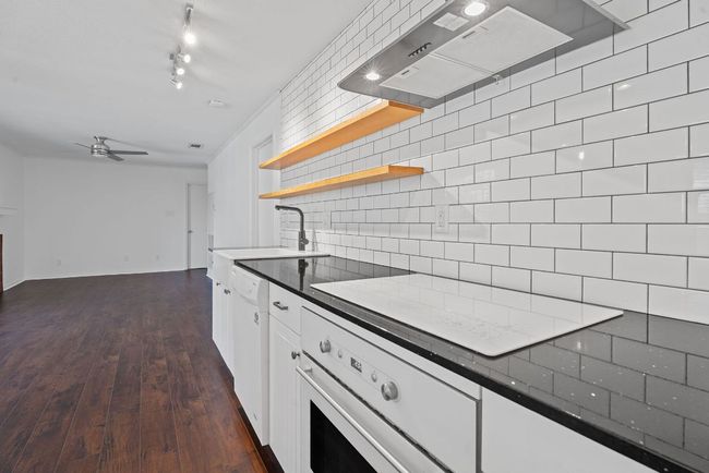 Appliances include a dishwasher, built-in oven, induction cooktop, and a chef's range hood. | Image 6