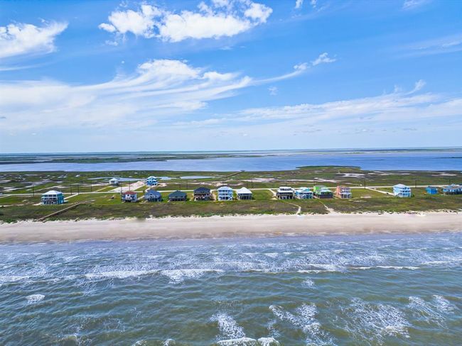 This aerial view captures the intentional layout of Seahorse Estates—just two rows of homes separated by over 50 acres of conservation land. Your new build at 5002 Blue Water Hwy will be perfectly positioned on the beachfront side, delivering unobstructed water views and maximum privacy. | Image 21