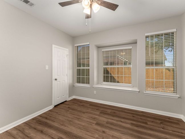 Unfurnished room with a ceiling fan, dark wood-style floors, visible vents, and baseboards | Image 20