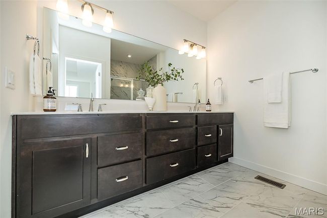 Bathroom with marble look tiles, double vanity, and a marble finish shower | Image 24