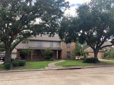 Ranch Style house has gorgeous live oaks and a long porch. Enjoy coffee or just watch the world go by from this comfy front porch. | Image 1