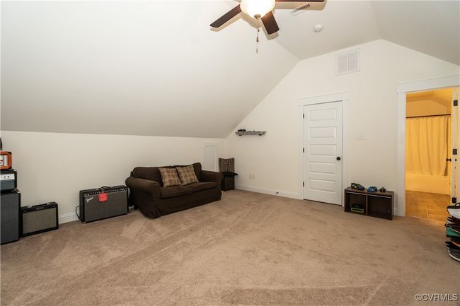 Sitting room with carpet floors, visible vents, lofted ceiling, and ceiling fan | Image 30