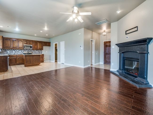 Unfurnished living room featuring baseboards, visible vents, ceiling fan, and light wood-style floors | Image 7