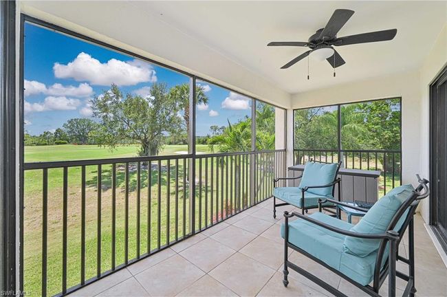 Sunroom featuring view of golf course and ceiling fan | Image 11