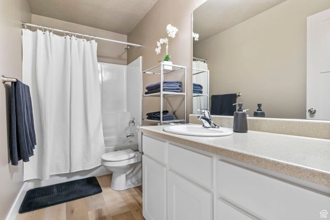 Full bathroom with shower / tub combo, vanity, toilet, and wood finished floors | Image 22