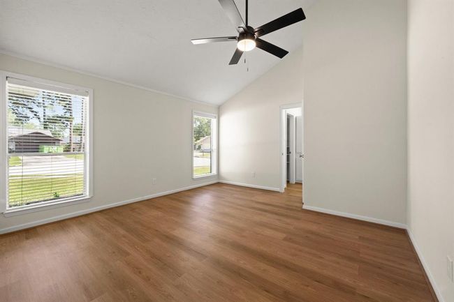 Relax in the spacious primary bedroom with updated lighting, and ceiling fan. A serene space to unwind at the end of the day. | Image 27
