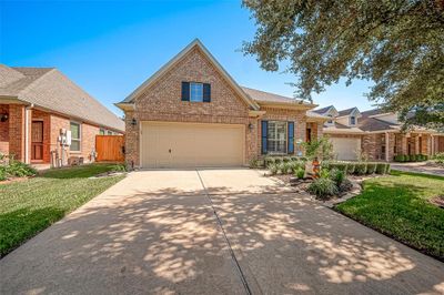 This lovely home features a spacious two-car garage that includes an extra storage area and a double wide driveway, providing ample parking for all your friends and family. | Image 2