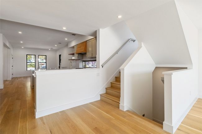 Stairs centrally located to the primary upstairs and guest room and washer and dryer downstairs | Image 27