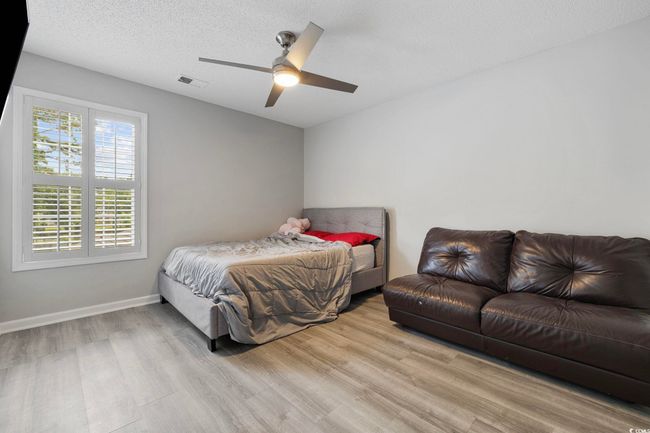 Bedroom with wood finished floors, a ceiling fan, baseboards, and a textured ceiling | Image 11