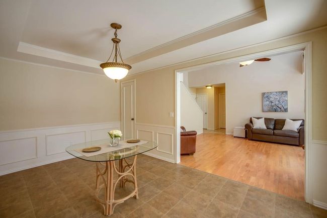 Dining room featuring a tray ceiling, crown molding, stairway, a wainscoted wall, and a decorative wall | Image 20