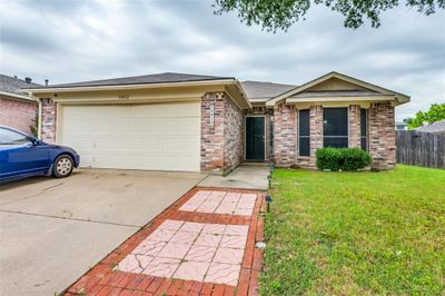 Ranch-style home featuring a garage and a front yard | Image 3