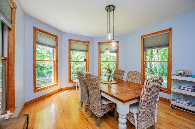 Delightful dining with hardwood floors and lined with windows, light and nature. | Image 11