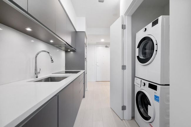 Laundry area with laundry area, stacked washer and dryer, a sink, and recessed lighting | Image 5