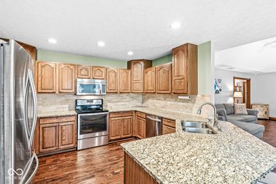 The kitchen is approximately 12 x 12 - granite countertops, tile backspace, and stainless steel appliances included. | Image 3