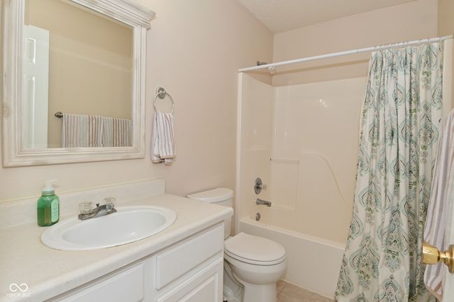 full bath featuring vanity, toilet, shower / tub combo, and tile patterned floors | Image 33