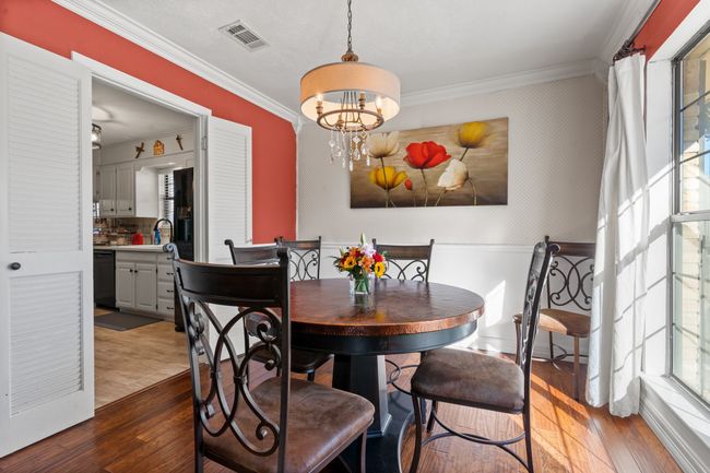 Dining space with a chandelier, hardwood / wood-style floors, crown molding, and sink | Image 7