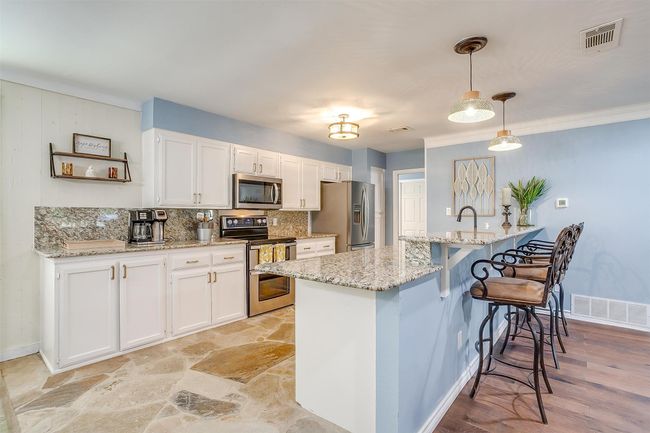 Kitchen with visible vents, white cabinetry, and stainless steel appliances | Image 21