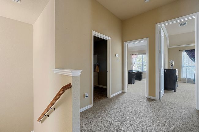 Hall with baseboards, visible vents, an upstairs landing, and carpet | Image 7