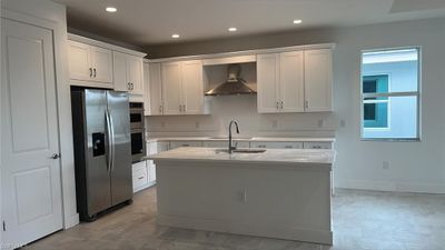 Kitchen layout with quartz countertops, soft-close cabinets and drawers, and stainless steel kitchen appliances | Image 2