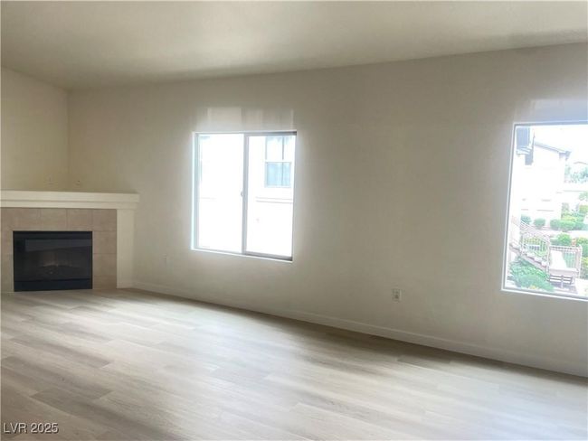 Unfurnished living room featuring light wood finished floors and a tiled fireplace | Image 8