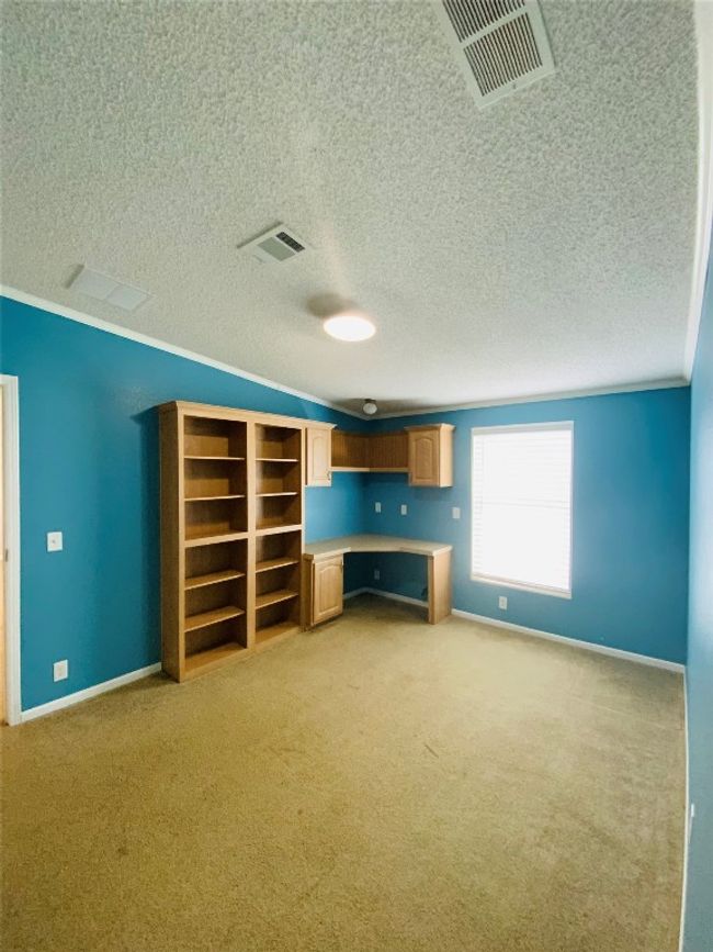 Unfurnished living room featuring light colored carpet, baseboards, a textured ceiling, and visible vents | Image 23