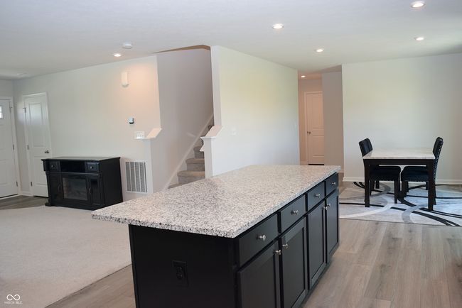 view from kitchen of great room, stairs to the upper level, dining area, and back hall to office | Image 20