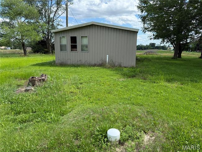 View of side of property with board and batten siding and an outbuilding | Image 7