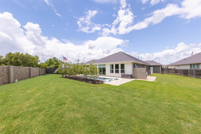 The backyard provides a delightful view of the house's rear, featuring a Generac 60HZ generator with a warranty until October 2027, offering reliable backup power. | Image 31