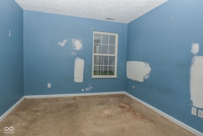 empty room with a textured ceiling, carpet, and baseboards | Image 13