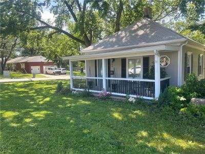 View of front of house featuring a garage, a front yard, and a porch | Image 1