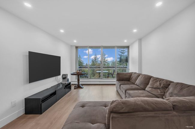 Living area with recessed lighting, light wood finished floors, baseboard heating, and expansive windows | Image 18