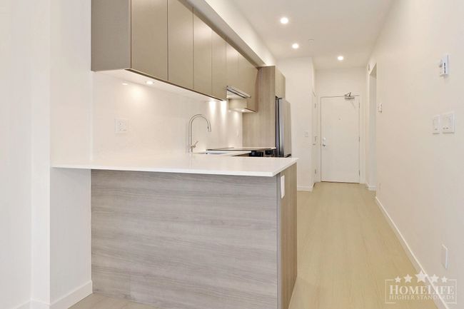 Kitchen with a sink, freestanding refrigerator, baseboards, modern cabinets, and light countertops | Image 6