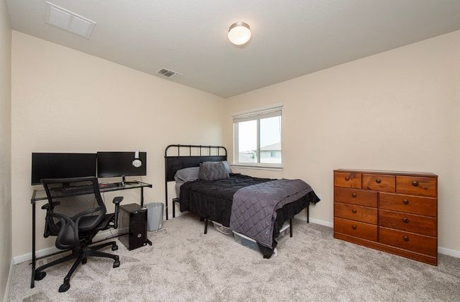Carpeted bedroom with a desk and baseboards | Image 19