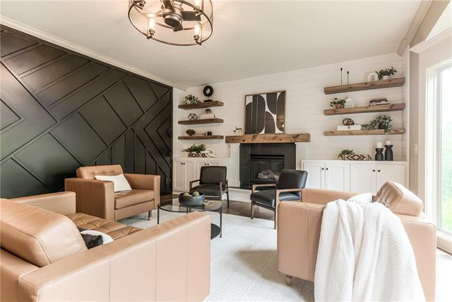 Living area with a fireplace and a chandelier | Image 14