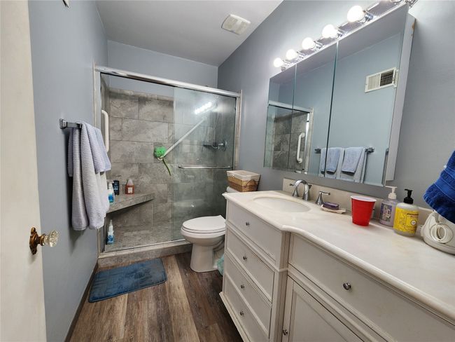 Full bath with a stall shower, visible vents, and wood finished floors | Image 26