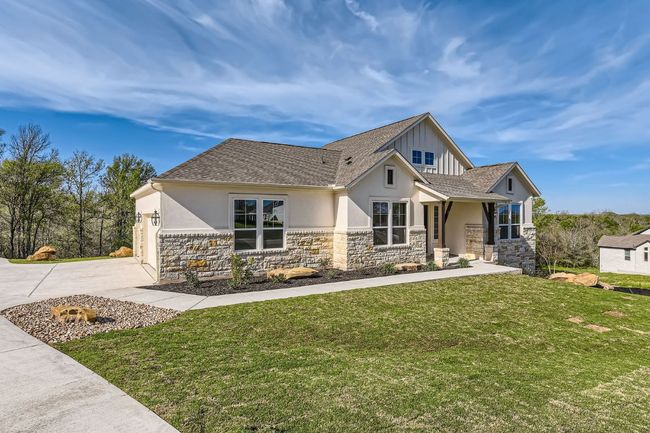 Craftsman-style home featuring stucco siding, a front lawn, driveway, and stone siding | Image 5