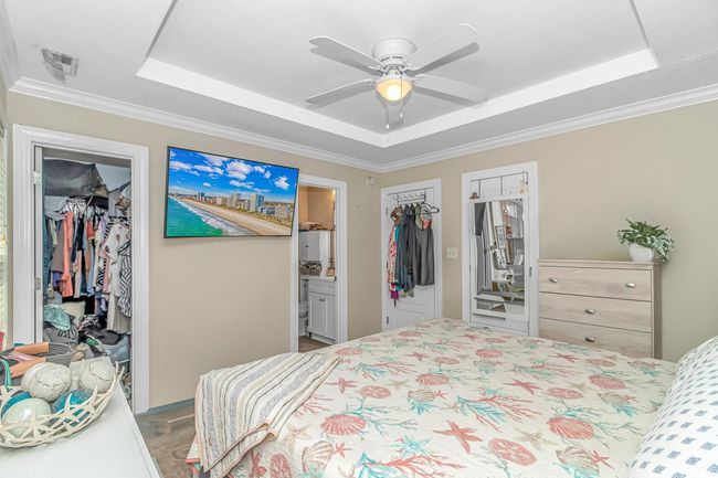 Bedroom with a raised ceiling, a closet, a walk in closet, ornamental molding, and ensuite bath | Image 17