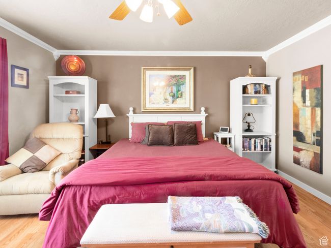 Bedroom featuring a ceiling fan, wood finished floors, and ornamental molding | Image 8