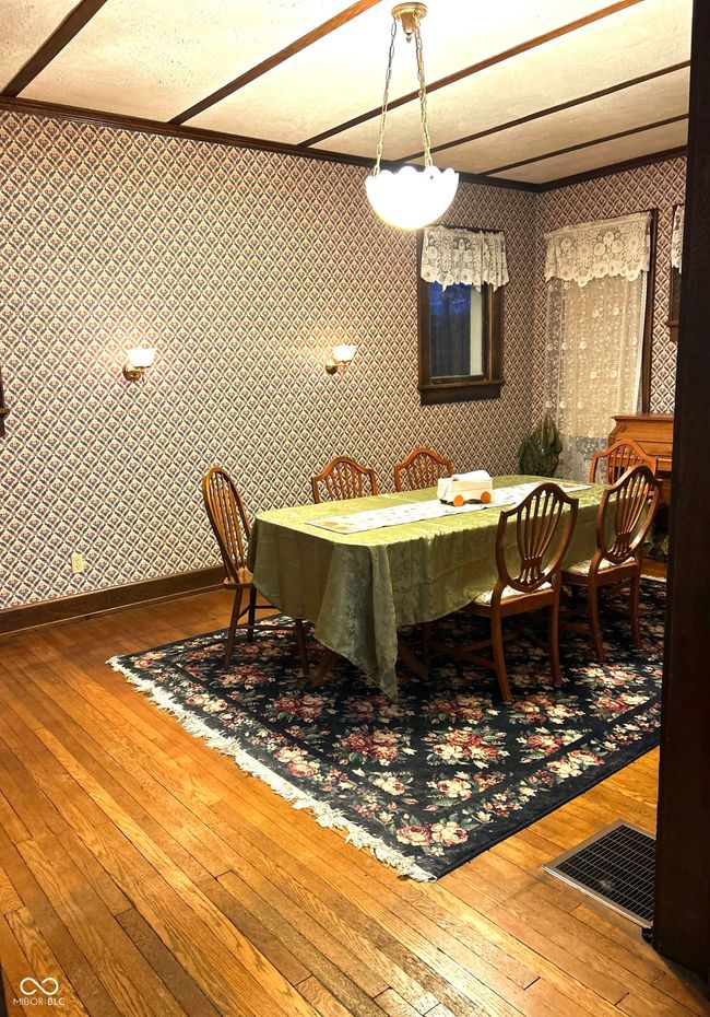 dining room featuring visible vents, baseboards, hardwood / wood-style flooring, and wallpapered walls | Image 13