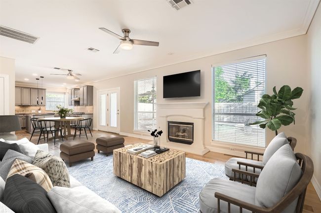 Living room with a wealth of natural light, a ceiling fan, crown molding, and visible vents | Image 11