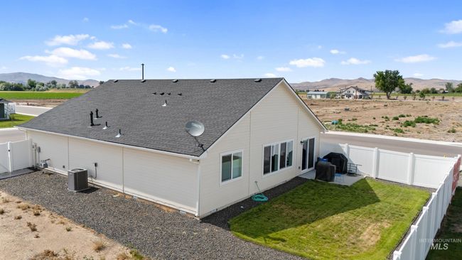 Rear view of house with a mountain view, a fenced backyard, and roof with shingles | Image 24