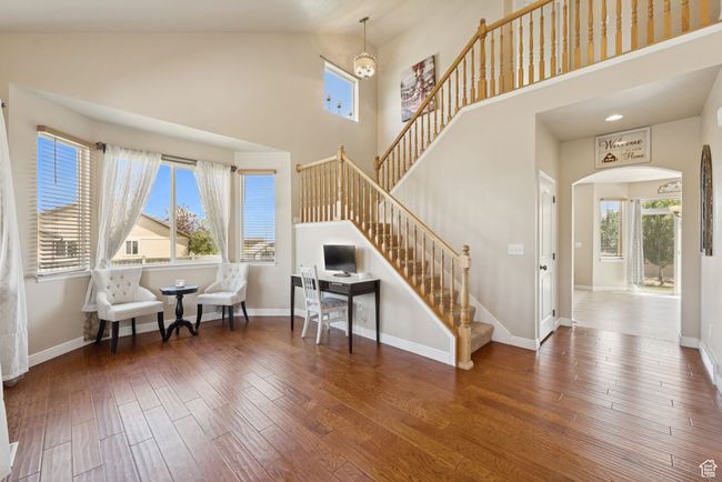 Sitting room featuring arched walkways, high vaulted ceiling, hardwood / wood-style flooring, and stairway | Image 7