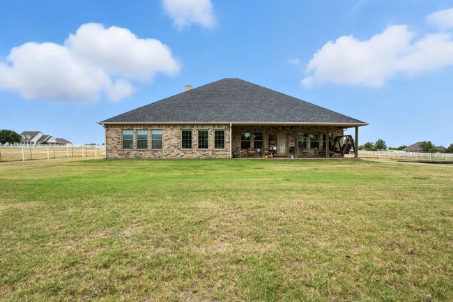 Rear view of property featuring a shingled roof, brick siding, and a chimney | Image 40