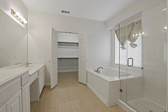 Bathroom with a shower stall, a bath, double vanity, and a spacious closet | Image 11