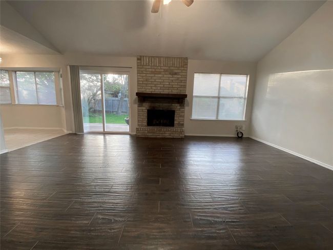 Unfurnished living room, a fireplace, and lofted ceiling | Image 7