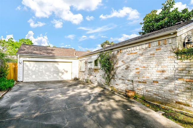 The attached garage sits above a pristine slate? driveway? | Image 44