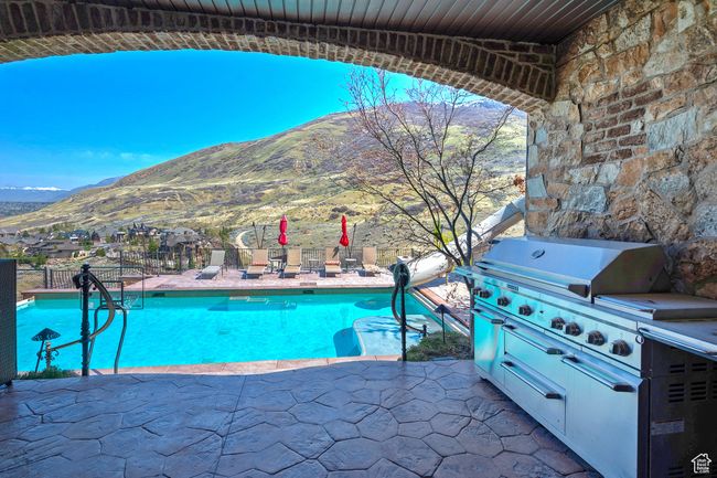 View of swimming pool with a patio, a mountain view, a fenced in pool, and fence | Image 55