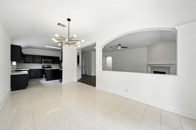 The spacious living room features a cozy gas fireplace and flows seamlessly into a large dining area—perfect for entertaining. | Image 13